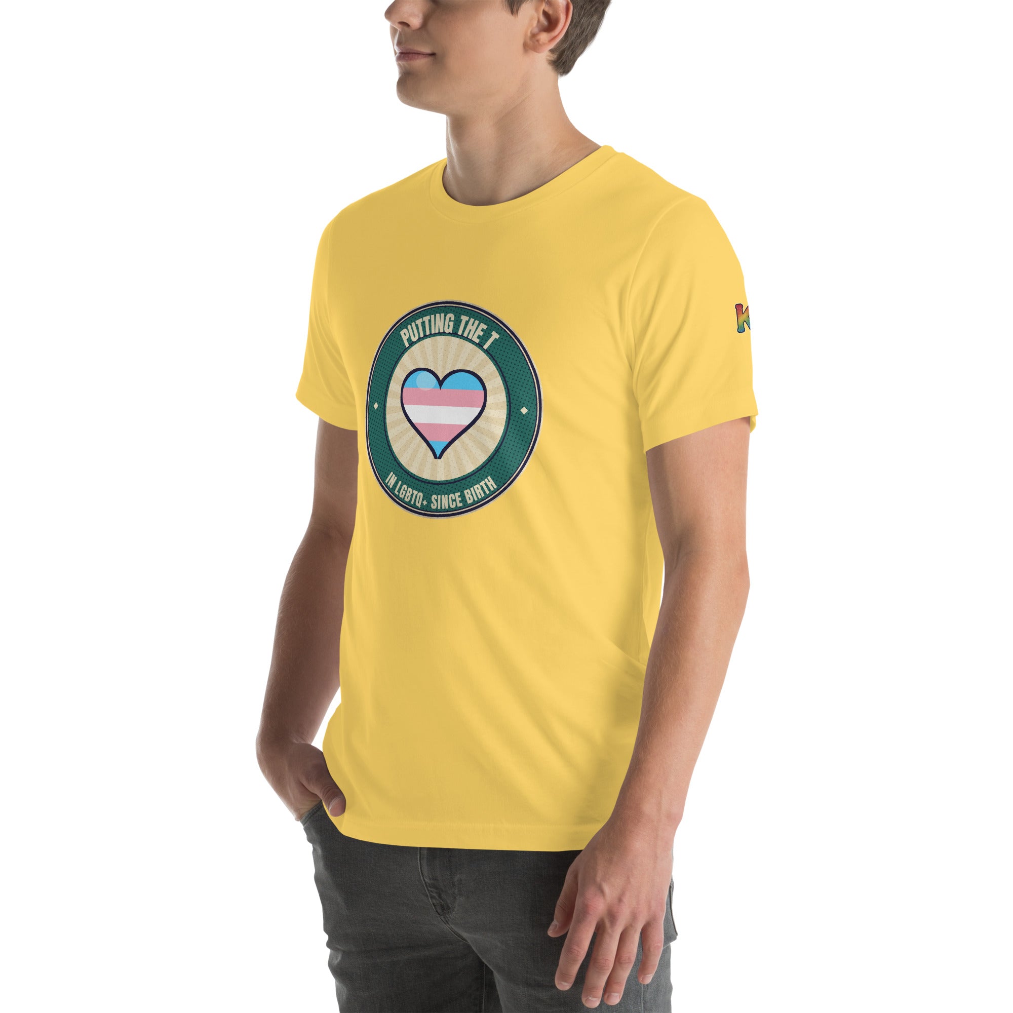 transgender pride t-shirt — Putting the T badge design, yellow tee left-front angled view (sleeve K visible)